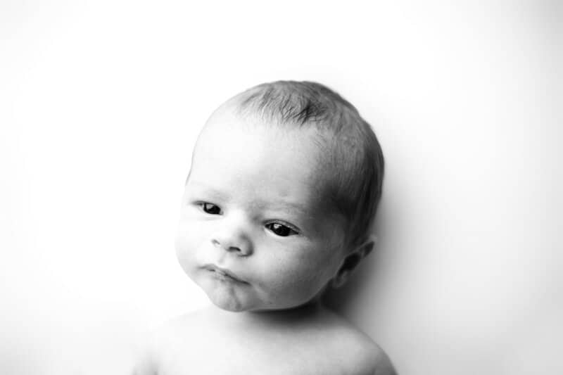 Newborn baby mugshot in black and white