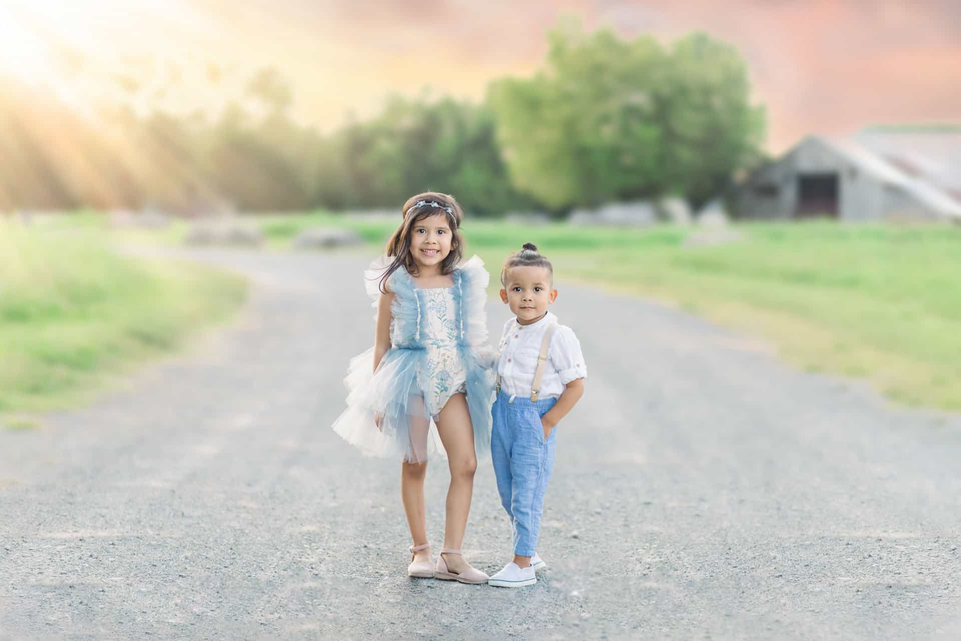 brother and sister in boutique clothing, posing at sunset, photographed by child photographer Amanda Barrett