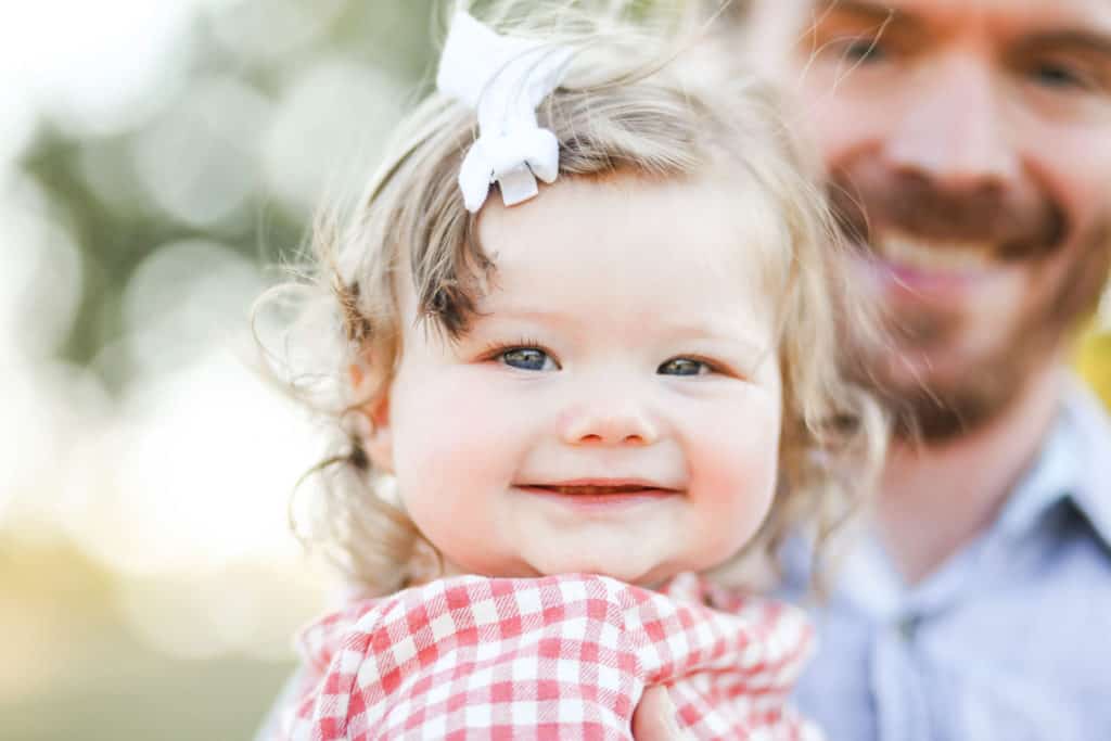 6 month old baby girl smiling for photo with dad
