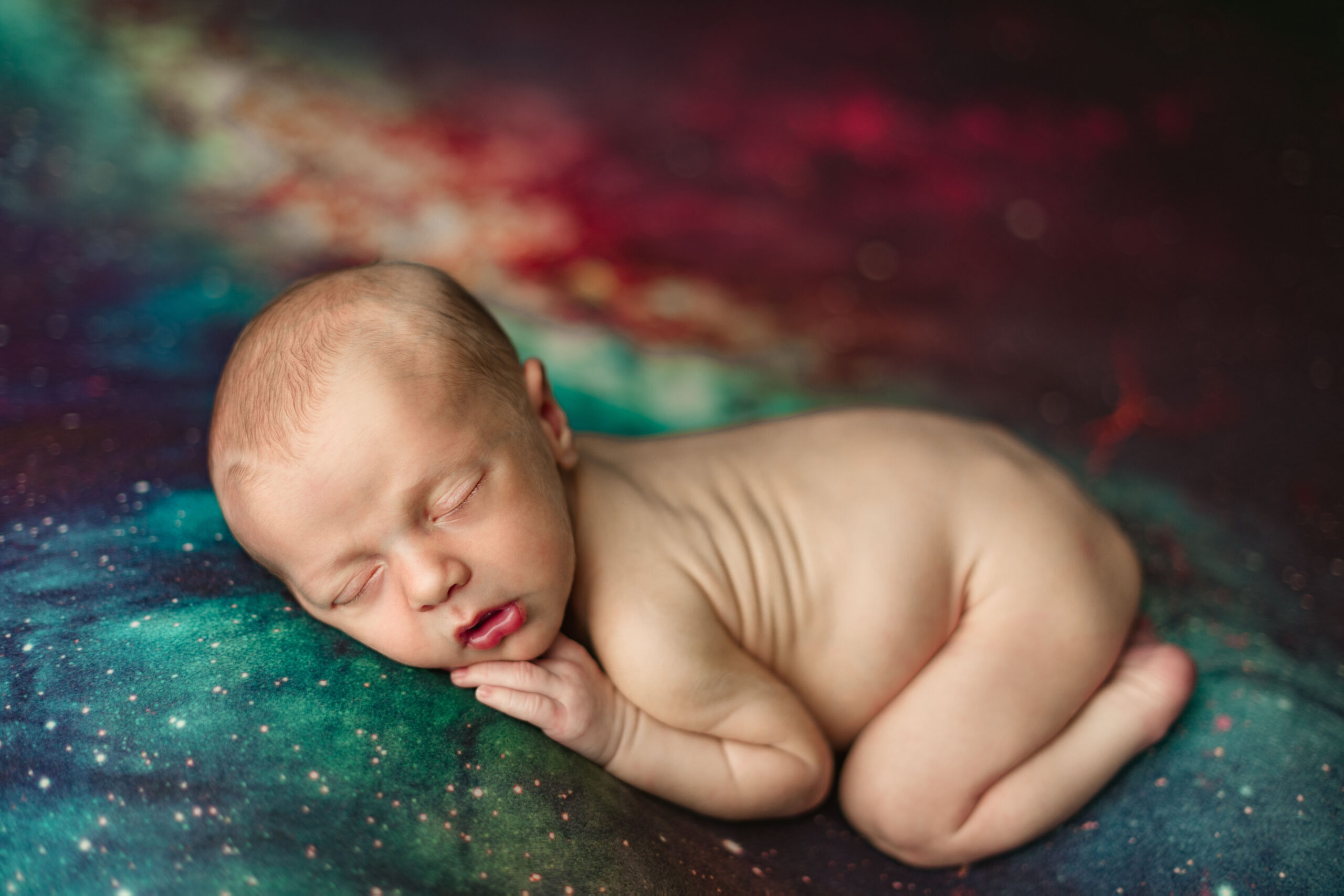 newborn baby laying naked on a space themed backdrop newborn baby wrapped in brown wearing a bear hat sleeping on a bed Nashville baby boutiques