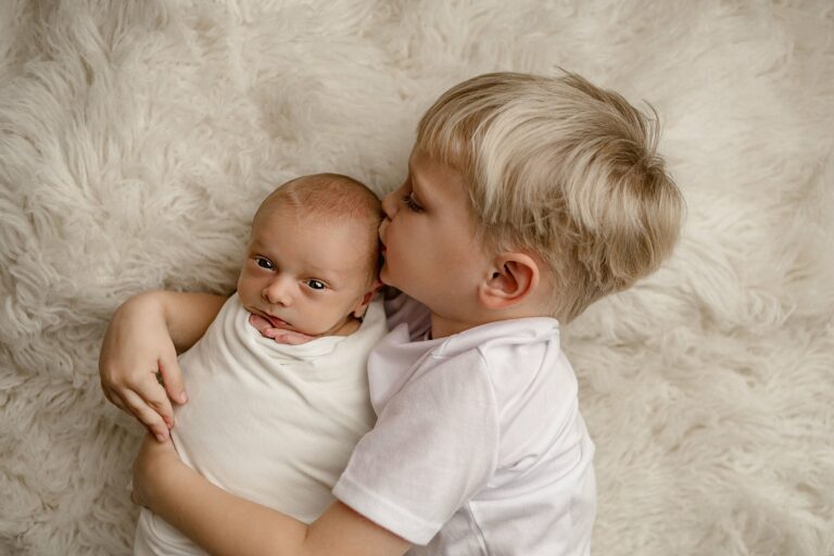 Big brother hugs and kisses newborn sibling on the head nashville nanny