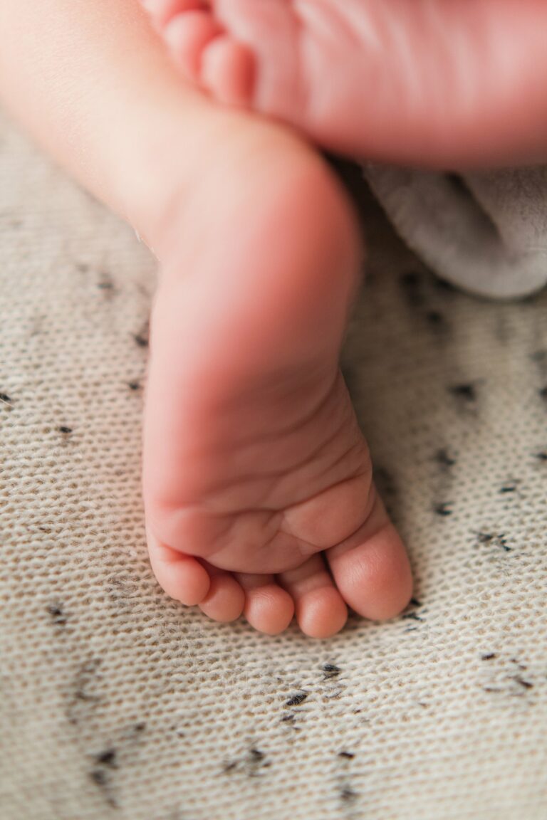 newborn baby feet on a white blanket