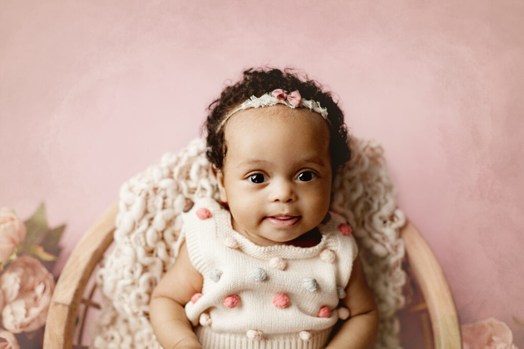 baby girl posed in basket on pink in amanda barrett photography studio